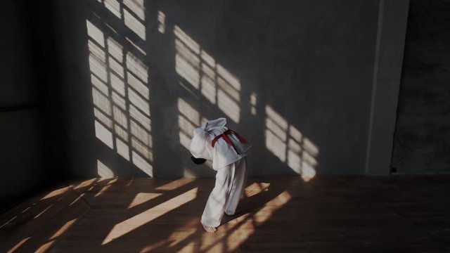 Slow motion. Stretchy Young Boy is preparing for a duel. Traditional martial arts. He bends his back forward and backward. Flexibility of the spine, body ownership.