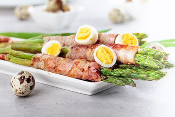 Asparagus wrapped in bacon with boiled quail eggs.