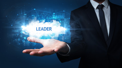 Hand of Businessman holding LEADER inscription, successful business concept