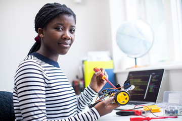 Fototapeta Portrait Of Female Teenage Pupil Building Robot Car In Science Lesson obraz