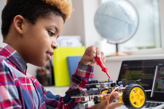 Male Elementary School Pupil Building Robot Car In Science Lesson