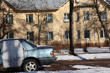 Old car on the street near the estate. Old cottage and old car