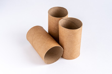One sleeve from the toilet paper is lying, and two bushings are standing upright in the center of the white table.