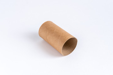 One toilet paper sleeve lies diagonally in the center of a white table.