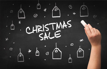 Hand drawing CHRISTMAS SALE inscription with white chalk on blackboard, online shopping concept