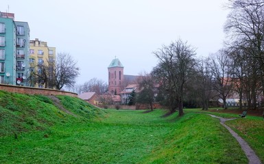 Fototapeta premium Former moat and Co-Cathedral of St. John the Baptist in background in Kamien Pomorski, Poland
