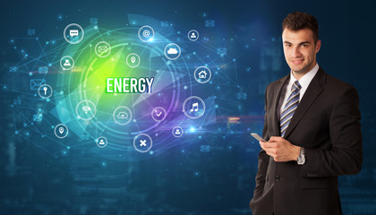 Businessman thinking in front of technology related icons and ENERGY inscription, modern technology concept