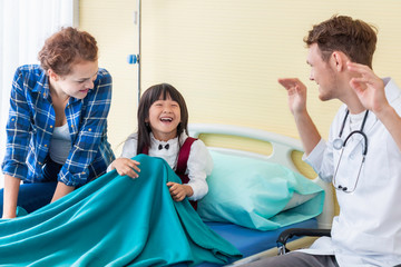 Pediatrician (doctor) man , mother and little daughter smiling in hospital.