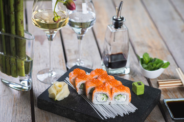 Traditional rolls with fish and rice on a white plate with sauce and wasabi. Japanese food.