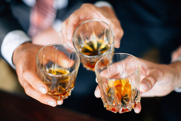 Men holding glasses of whiskey. Soft focus