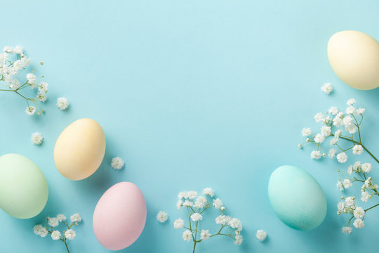 Pastel Easter Eggs On Blue Background Top View. Flat Lay Style.