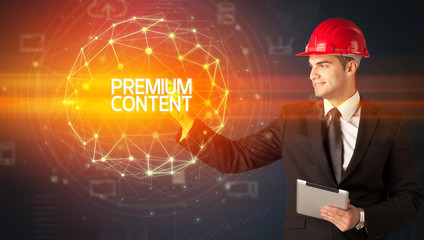 Handsome businessman with helmet drawing PREMIUM CONTENT inscription, social construction concept