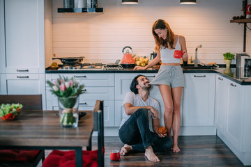 Young loving couple in the morning in the kitchen at home
