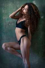 Curly hair girl fitness body in black bikini