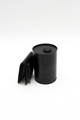 a black barrel of oil and men's wallet on a white background. The problem of oil pollution. The oil crisis, the fall in oil prices