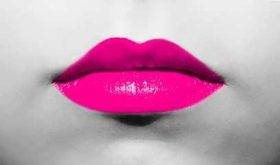 Female lips close-up with burgundy lipstick bright juicy color on a background of black and white face.