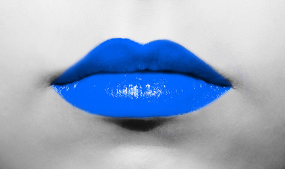 Female lips close-up with deep blue lipstick bright juicy color on a background of black and white face.