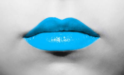Female lips close-up with light soft blue lipstick bright juicy color on a background of black and white face.