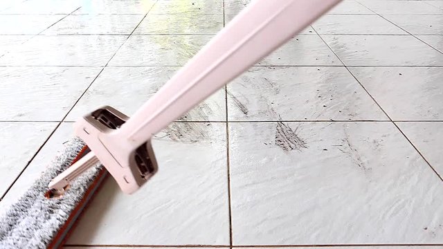 Cleaning the tile floor with a mop