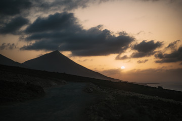 Obraz premium Sunset at Cofete beach with huge mountain and cloudy sky