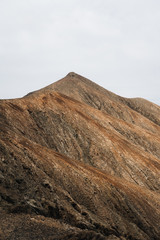 Desertic and arid mountains in Canary Islands with clean white sky