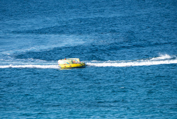 speedboat people tubing on the blue sea