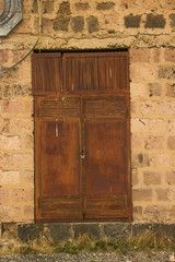old rusty steel door of secret laboratory in stone wall