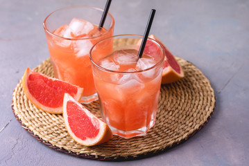 Two Glasses of Tasty Grapefruit Cold Drink or Cocktail on Gray Background Refreshment Beverage Cold Grapefruit Juice