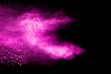 Pink powder explosion on black background.Pink dust splash cloud on dark background.