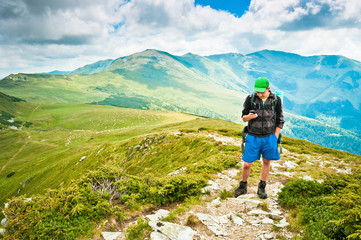 Fototapeta na wymiar Man using a mobile phone in the mountains, hiking, gps orientation, interactive maps