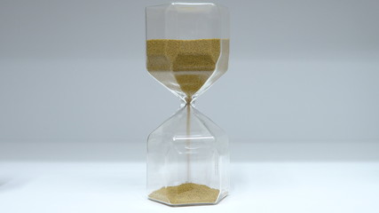 Hourglass close up. Glass hourglass with small balls instead of sand.