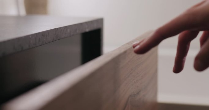 Slow motion man hand open and close batroom cabinet drawer closeup