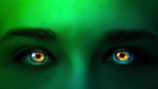 Creative 4k video of a slowly flying ash against the background of a epic woman's face of mystic green color with beautiful multi-colored eyes close-up. Mysterious look. Glowing eyes in the darkness.