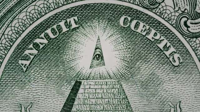 Creative 4k parallax video of details of 1 American dollar banknote with a rotating eye at the top of the pyramid. Macro view.