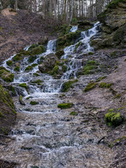 A stream of water flowing over rocks and creating a waterfall effect.