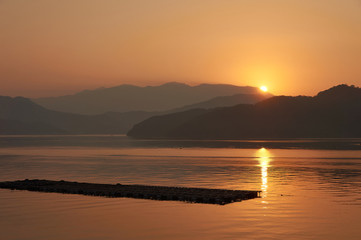 Obraz premium 水産養殖筏。 日本の漁村の風景。 鮮やかなオレンジ色の夕日。