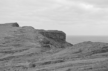 Fototapeta premium Panoramic view of an arid cliff landscape with trekking pathways in the Atlantic Ocean (Madeira, Portugal, Europe)