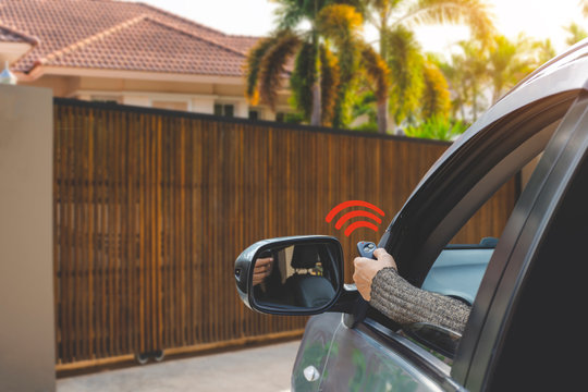 Woman in car, hand using remote control to open the auto gate when driving and arrive home. Automatic door, security system and wireless concept.