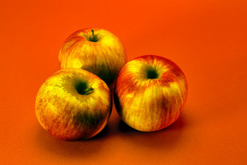 Ripe red red apples close-up isolate on a orange background.
