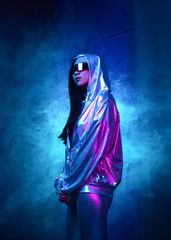 Neon portrait of a girl of Asian appearance, dressed in futuristic clothes and glasses. Neon blue and pink light. Virtual reality glasses