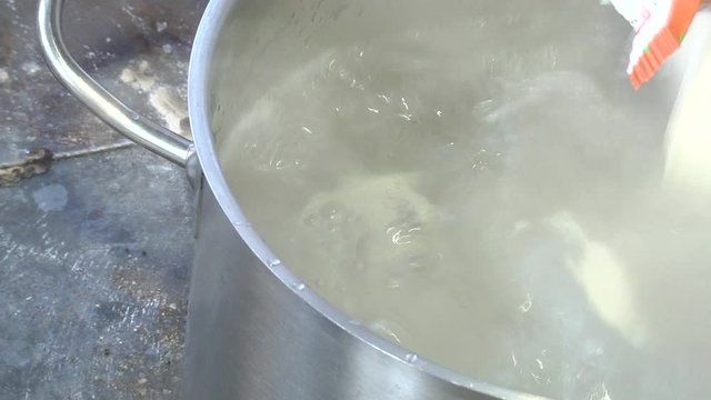 Pelmeni in boiling water. Closeup of metal stewpan with boiling water and dumplings. Home cooking. Dumplings in boiling water. Meat dumplings are boiled in a pot of boiling water.