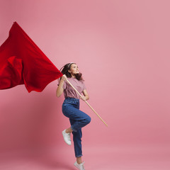 Young and beautiful girl with a red flag on a pink background. A socially active woman, to protest...