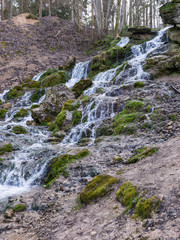 A stream of water flowing over rocks and creating a waterfall effect.