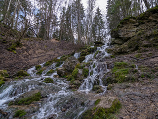 A stream of water flowing over rocks and creating a waterfall effect.