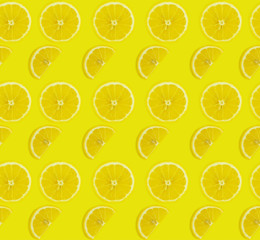 Fruit pattern of real lemon slices on yellow background