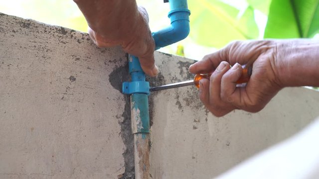 Plumber Repairing broken water pipes in bathroom, Technician Asian elderly Worker  builder, repairman with Tools Repair Leaking Pipe. Talented foreman elderly people adjustable wrench holds plumbing