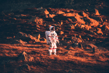 Astronaut exploring a new planet. Searching for a new home for humanity. Concept about science and...