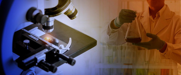 Laboratory concept; close up of microscope with a blurred picture of the scientist is researching in laboratory