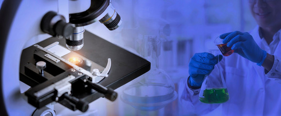 Laboratory concept; close up of microscope with a blurred picture of the scientist is researching in laboratory