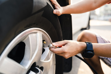 Close up of asian man inflating tire in the gas station.